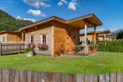 slider-20 Holzhaus mit Sattelach und grünem Rasen im Vordergrund.