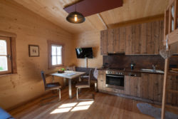 slider-5 Innenansicht eines Hauses mit Sofa, Sitzgruppe. Küchenzeile und Fernseher.