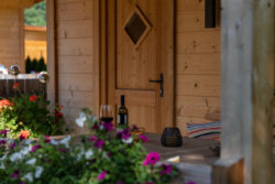 slider-7 Holztür. Im Vodergrund Blumen, ein Weinglas und eine Weinflasche.