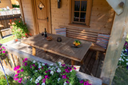 slider-8 Aufnahme von Oben. Veranda mit Tisch, Wein, Brezeln, Sitzgelegenheit und Blumen sind zu sehen.